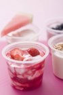 Cuatro yogures con bayas y cereales - foto de stock