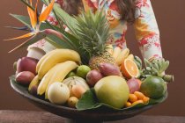 Woman holding bowl of exotic fruit — Stock Photo