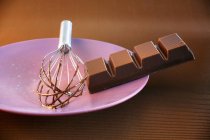Stück Schokolade auf violettem Teller — Stockfoto