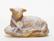 Closeup view of baked Easter lamb with icing sugar and ribbon — Stock Photo