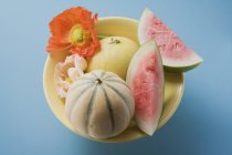 Fresh ripe melons with flowers — Stock Photo