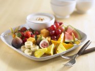 Plate of fruits with dip — Stock Photo