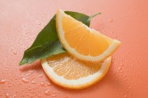 Orangenkeil und Scheibe mit Blatt — Stockfoto