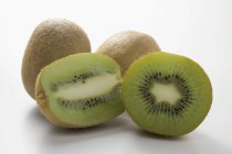 Frutas Kiwi, inteiras e cortadas pela metade — Fotografia de Stock