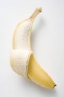 Частично очищенный свежий банан — стоковое фото