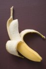 Half-peeled ripe banana — Stock Photo