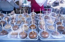 Крупный план конфет яблоки с палочками на лотки — стоковое фото