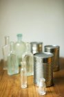 Vista elevada de botellas y latas surtidas en la superficie de madera - foto de stock