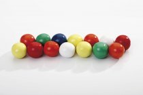 Vista de cerca de bolas de goma de mascar de colores en una fila - foto de stock