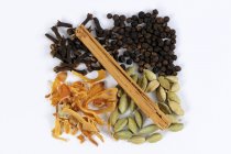 Closeup top view of cloves with mace, cardamom, cinnamon stick and peppercorns — Stock Photo
