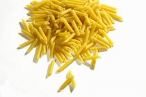 Heap of raw penne pasta — Stock Photo