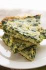 Slices of Chopped Spinach Frittata; Stacked on White Plate — Stock Photo