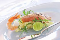 Salmon and prawn on fettuccine pasta — Stock Photo