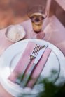 Elevated view of place setting and glass of wine on pink chair — Stock Photo