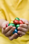 Mani che tengono uova di cioccolato — Foto stock