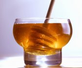 Honey in glass with dipper — Stock Photo
