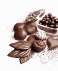 Chocolates e folhas de chocolate — Fotografia de Stock