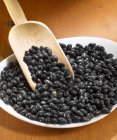 Black beans with wooden scoop — Stock Photo