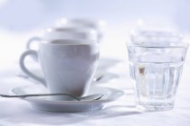Vue rapprochée de trois tasses d'Espresso avec des verres d'eau — Photo de stock