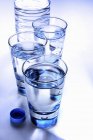 Gläser mit klarem Wasser und Plastikflasche — Stockfoto