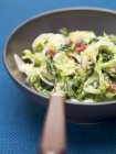 Savoy cabbage with bacon in saucepan over blue surface — Stock Photo