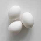 Trois œufs blancs — Photo de stock