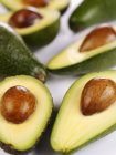 Diversi avocado interi e dimezzati — Foto stock