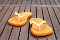Closeup view of two flip-flops on decking — Stock Photo