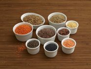 Vista elevada de vários tipos de lentilhas em pequenas tigelas — Fotografia de Stock