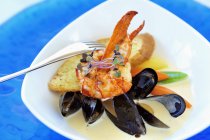 Closeup view of lobster and mussel stew with sprouts — Stock Photo
