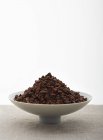 Closeup view of mound of cocoa nibs in a bowl — Stock Photo
