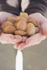 Human Hands holding almonds — Stock Photo
