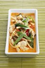 Primo piano vista del curry di tacchino tailandese rosso in piatto bianco — Foto stock