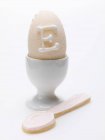 Vista de primer plano de huevo de azúcar en taza de huevo con cuchara horneada - foto de stock