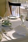 Daytime view of table set with white linens and ice water — Stock Photo