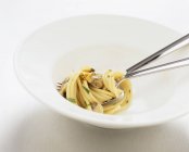Espaguete com amêijoas em tigela branca — Fotografia de Stock