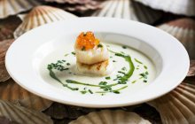 Scallop soup with salmon caviar — Stock Photo