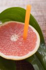 Pink grapefruit with straw — Stock Photo