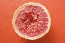 Стиснув рожевий грейпфрут — стокове фото