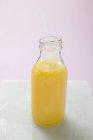 Orange juice in glass bottle — Stock Photo