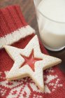 Jam-filled star biscuit on woolen mitten — Stock Photo