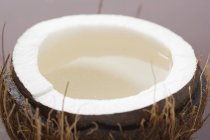 Die Hälfte der Kokosnuss mit Wasser — Stockfoto