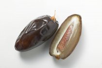 Whole and halved dates — Stock Photo