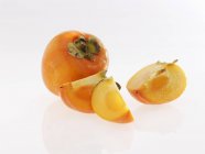 Fresh ripe persimmon with slices — Stock Photo