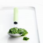 Espinacas en una cuchara en bandeja blanca - foto de stock