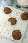 Vue surélevée des biscuits à l'avoine sur morceau de papier avec jeu de noughts et croix — Photo de stock