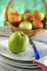 Яблоко на тарелках с ножом — стоковое фото