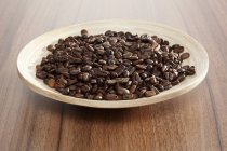 Plato de granos de café tostados - foto de stock