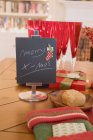 Frohe Weihnachten auf schwarze Tafel neben Gläser schreiben und auf den Tisch am Kamin stellen — Stockfoto