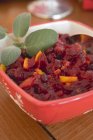 Closeup view of cranberry sauce  with leaves in bowl — Stock Photo
